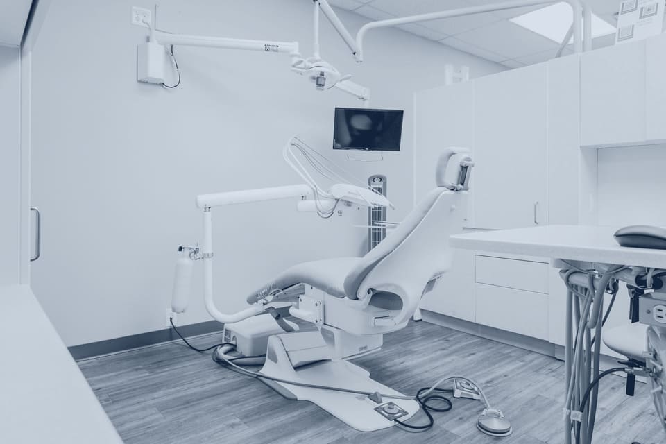 Cabinetul clinicii: fotoliul, lampa pe braț și dulapurile deschise la culoare